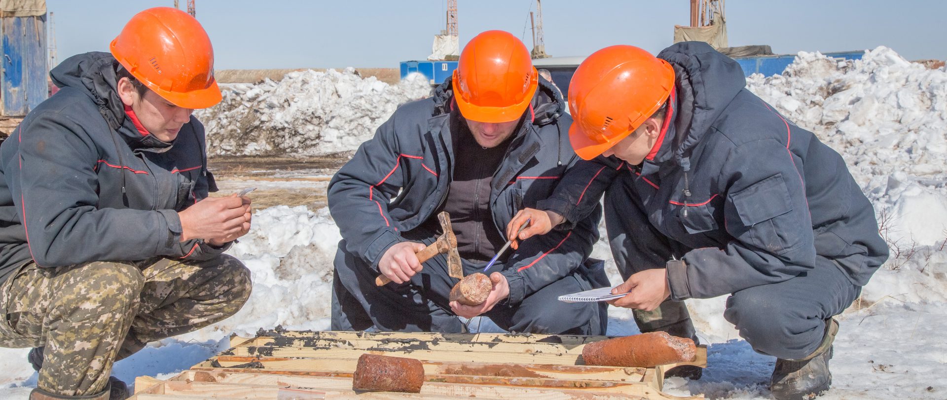 Геологи изучают образец керна на буровой площадке